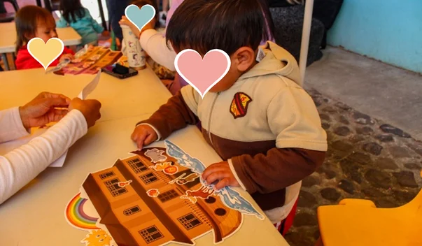 Niño armando un rompecabezas de cartón en el salón de clases
